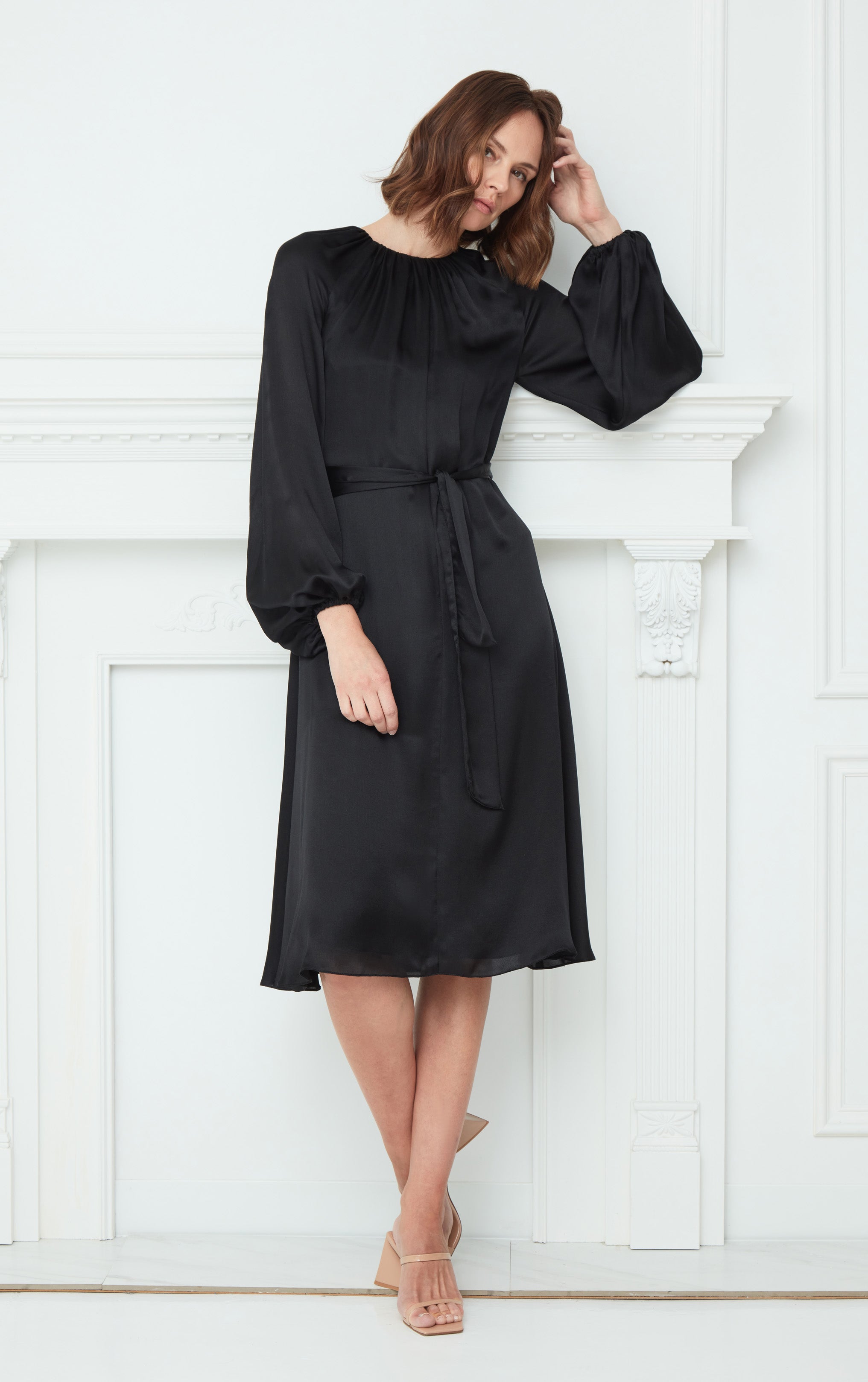 woman wearing black puff sleeve silk dress with rusched neck