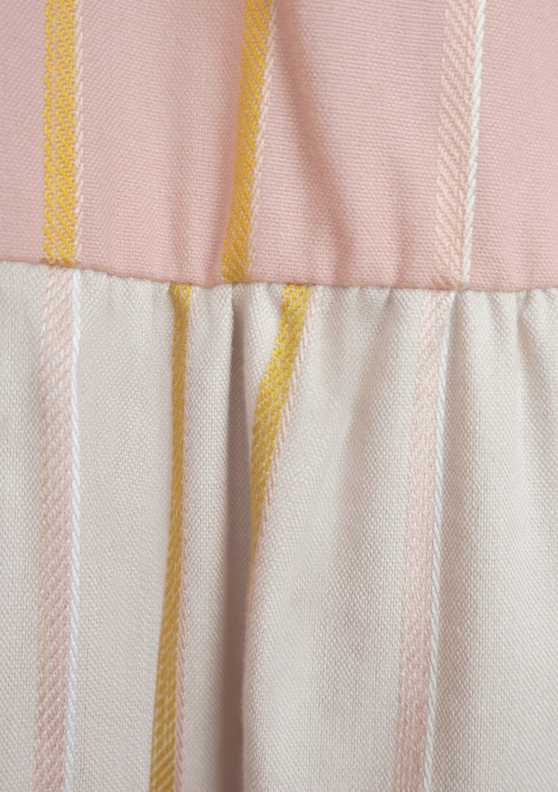 close up view of pink multi stripe sleeveless handwoven dress
