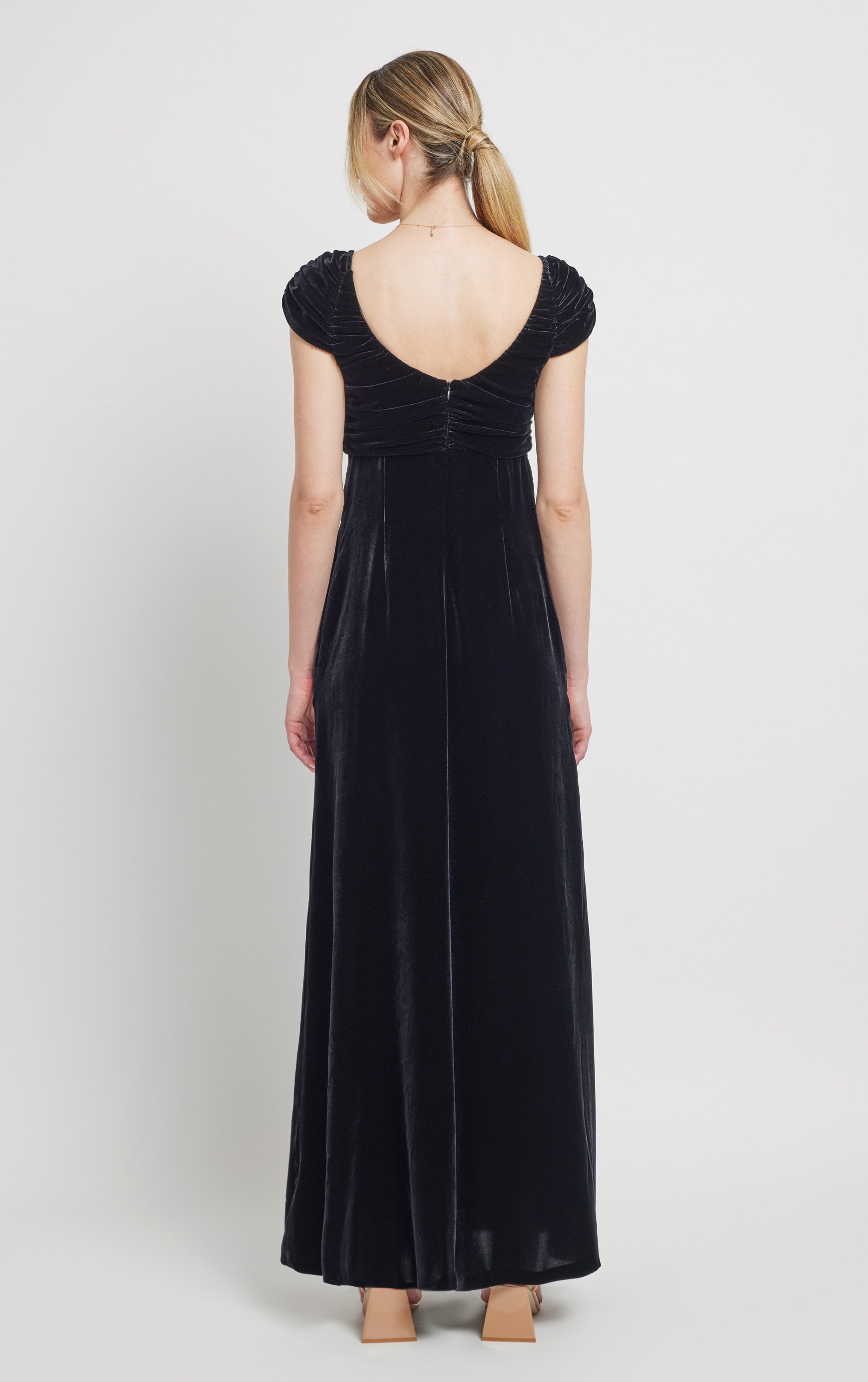 back view of woman wearing silk velvet black jumpsuit with front bow