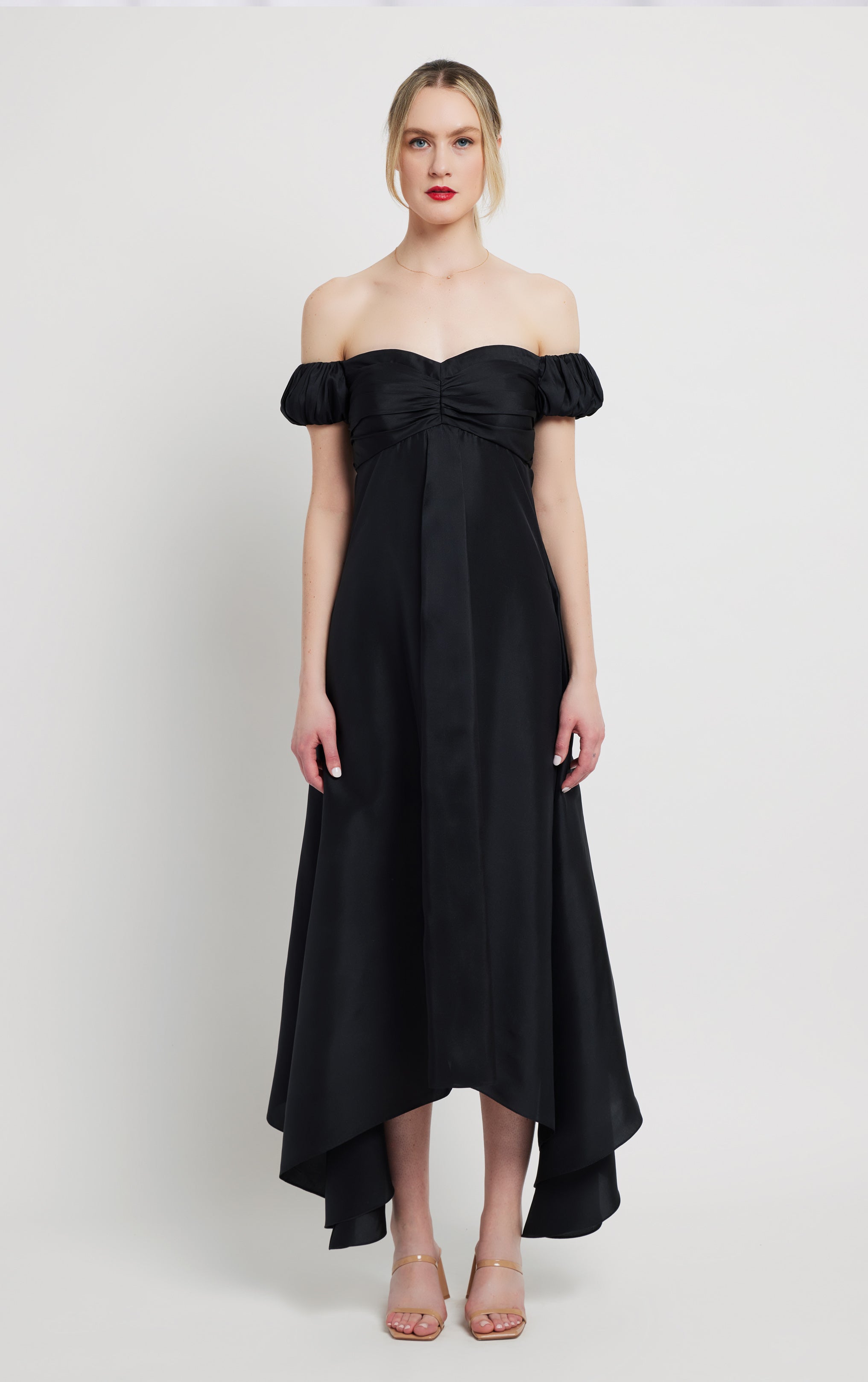 woman standing wearing long silk black off the shoulder dress