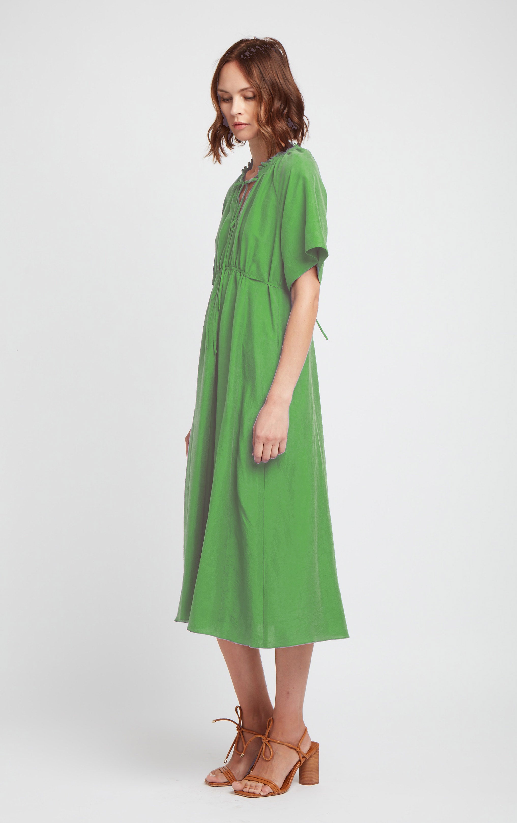 side profile of green short sleeved silk dress with ruffled neck trim and rusched neck