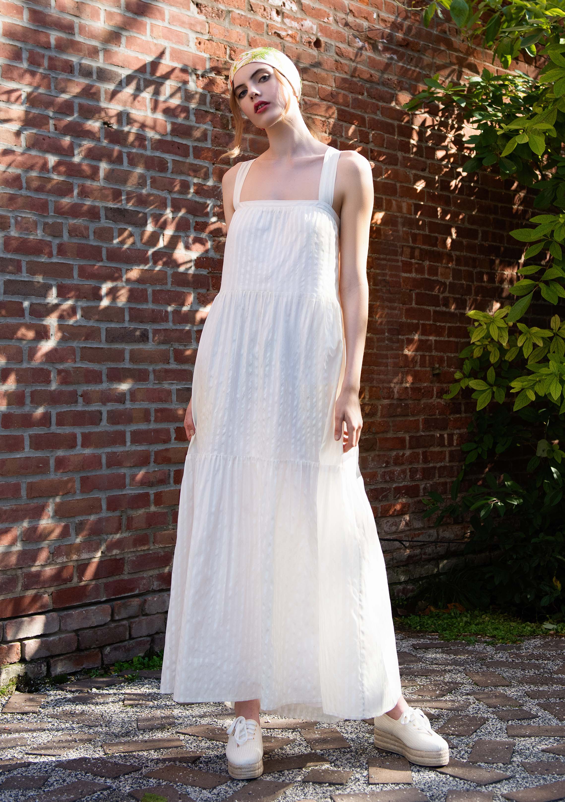 front profile view of woman wearing white sleeveless cotton silk blend dress