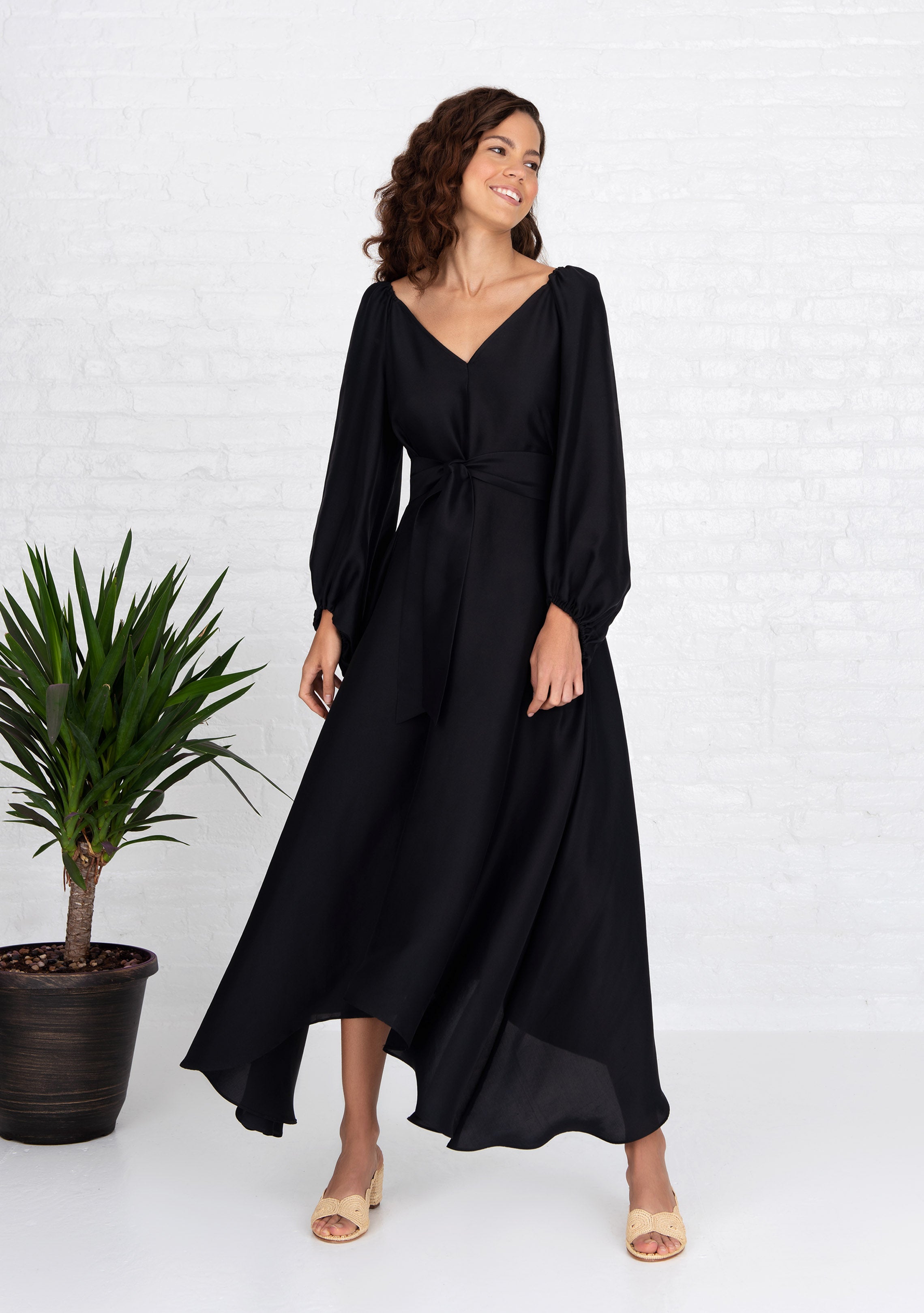 front view of woman wearing black puff sleeve silk dress front and back v neck with heels
