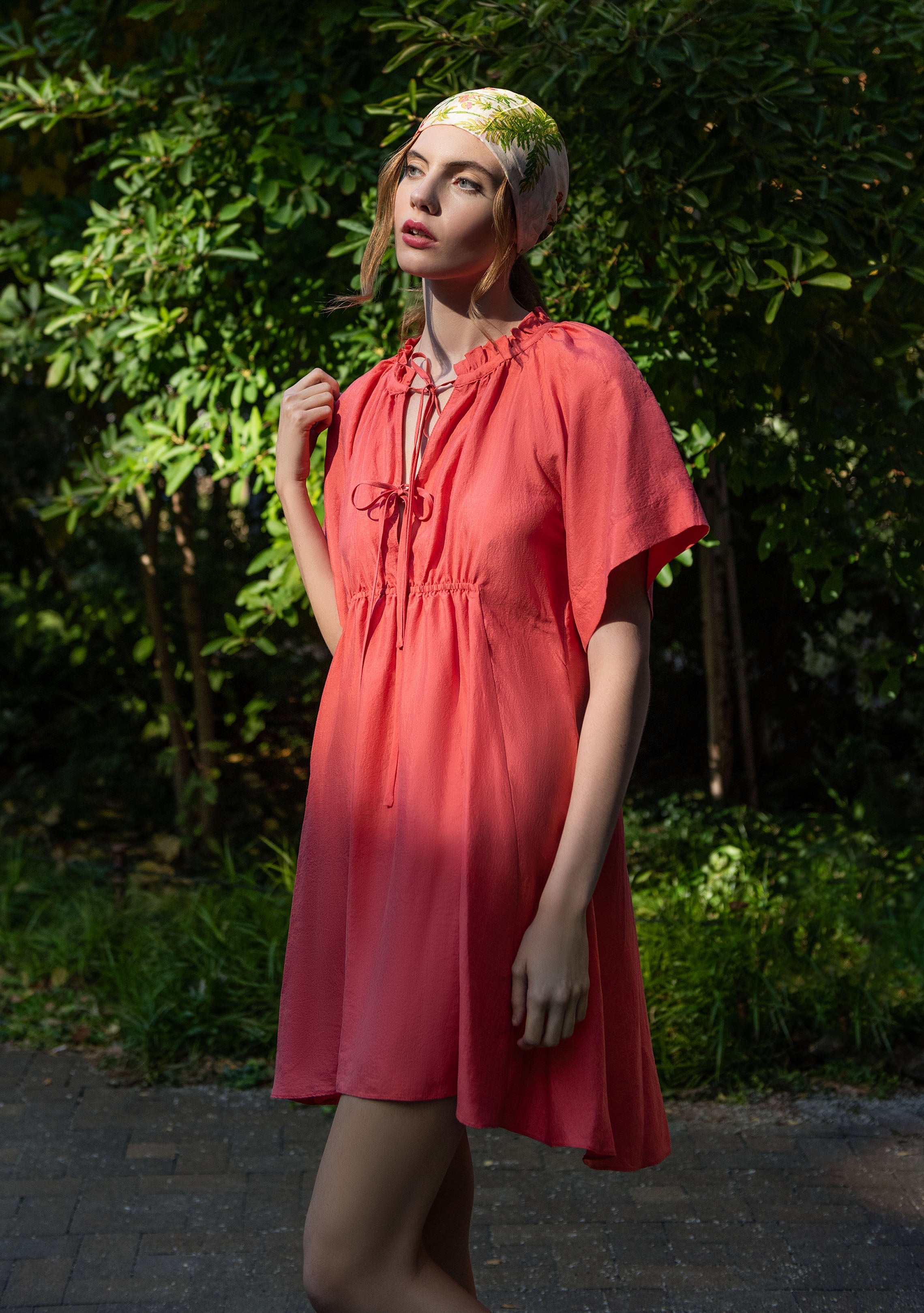 woman outside wearing coral short sleeved silk dress handwoven